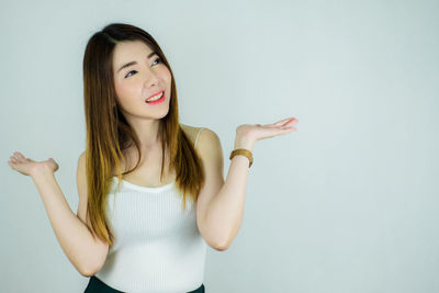 Portrait of a smiling young woman against white background