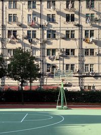 Empty road amidst trees and buildings in city