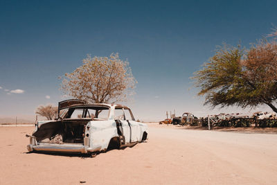 Abandoned car on road against sky