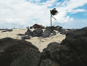 Rock formations on beach against sky