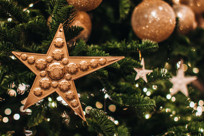 Holiday wallpaper. christmas tree green branches decorated with golden star and christmas balls