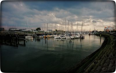 Sailboats moored in harbor