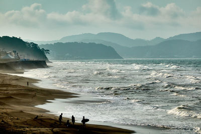 Scenic view of sea and mountains against sky