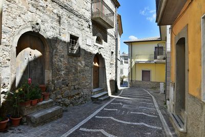 A narrow street among the old houses of greci, a village in the campania region, italy.