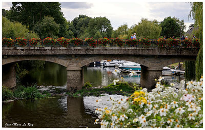 Arch bridge over river against sky