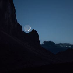 Low angle view of silhouette mountain against sky at night