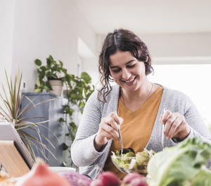 Portrait of a smiling young woman sitting at home
