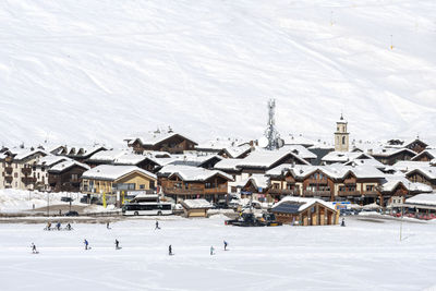 High angle view of snow covered houses by buildings