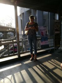 Full length of woman standing on escalator