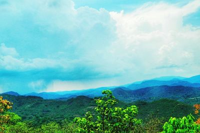 Scenic view of mountains against cloudy sky