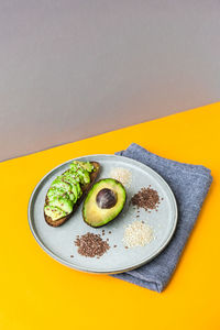 Ingredients for healthy avocado toast. ripe hass avocado, wholegrain bread, sesame flax seeds. vegan