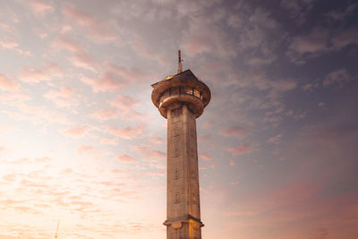 Low angle view of tower and building against sky during sunset