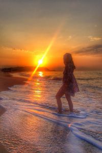 Silhouette of people on beach at sunset