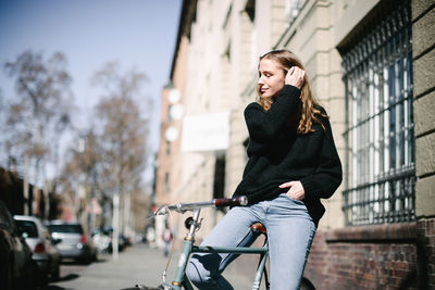 Full length of woman on bicycle in city