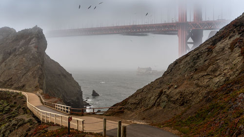 Bridge over ocean in fog