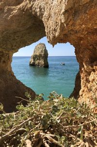 Scenic view of rock formation in sea against sky