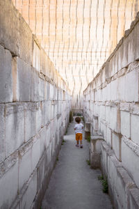 Rear view of woman walking on footpath