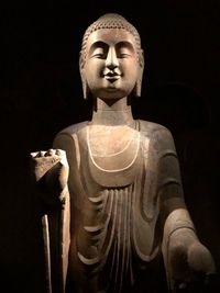 Statue of buddha against black background