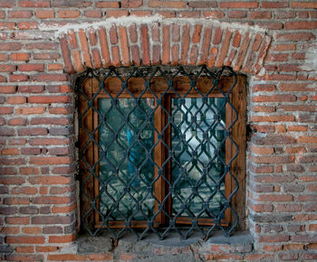 Close-up of metal structure against brick wall