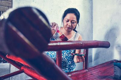 Portrait of woman looking through metal railing