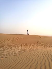 Scenic view of sand dunes against clear sky