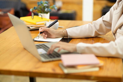 Midsection of businesswoman working at desk