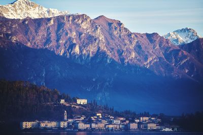 Panoramic shot of buildings by mountain against sky