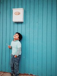 Portrait of woman standing against wall