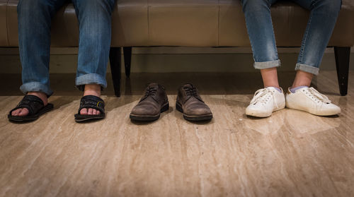 Low section of people sitting on sofa 