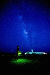 Man standing on landscape against starry blue sky