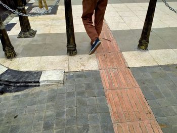 Low section of man standing on footpath