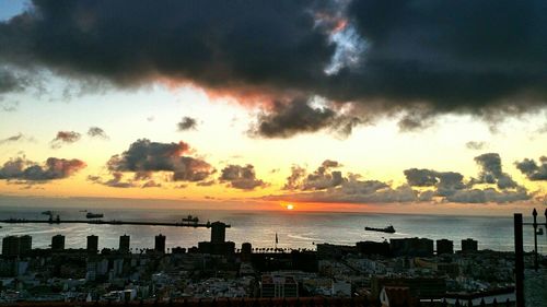 Scenic view of sea against cloudy sky at sunset