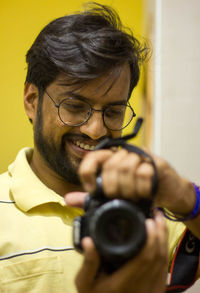 Portrait of smiling man holding eyeglasses