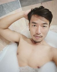 Portrait of shirtless man in bathroom