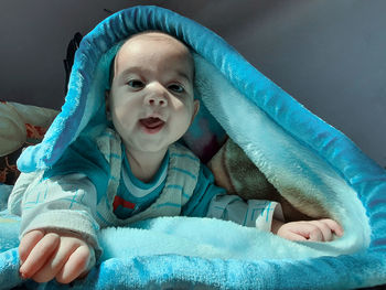 Portrait of cute baby lying on bed at home