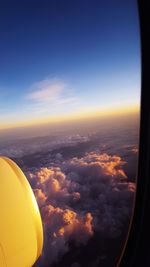 Aerial view of airplane wing against sky during sunset