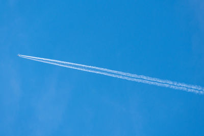 Low angle view of vapor trail against blue sky