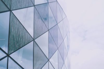 Low angle view of glass building against sky