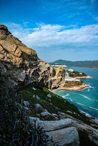 Rock formations by sea against sky