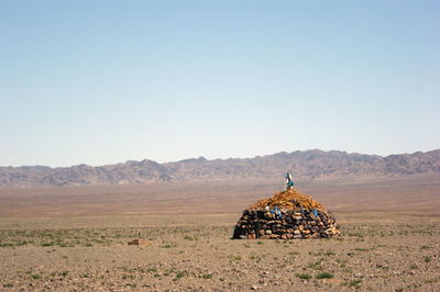 Traditional windmill on field against clear sky