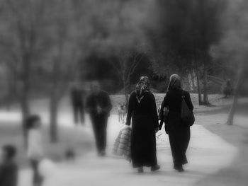 Rear view of people walking on road