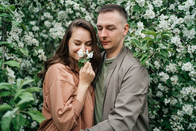 Portrait of smiling couple standing against plants