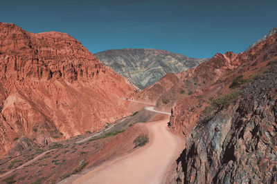 Dusty road with colorful mountains in purmamarca, argentina.