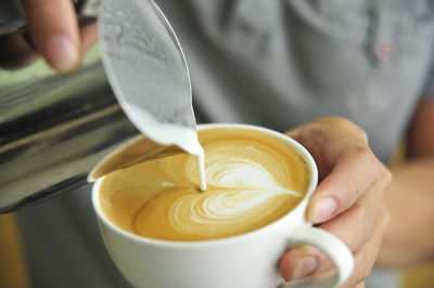 Cropped image of person holding coffee cup