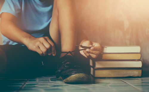 Midsection of woman reading book while sitting on table