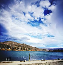 Scenic view of beach against cloudy sky