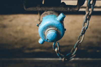 Close-up of blue chain hanging on metal