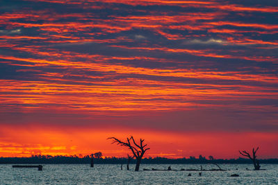 Scenic view of sea against dramatic sky during sunset