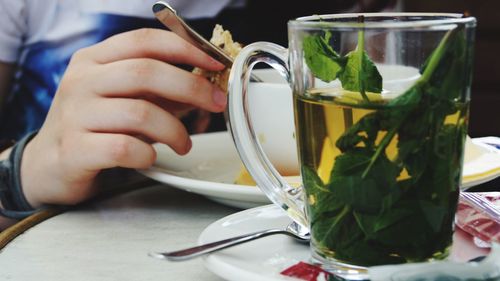 Midsection of woman having food at table