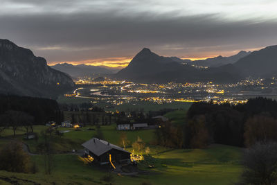 Scenic view of buildings and mountains against sky during sunset